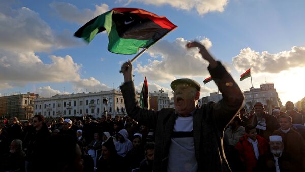 Un hombre con la bandera de Libia - Sputnik Mundo