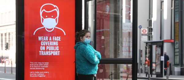 Una chica con mascarilla en una parada de autobús en Londres, Reino Unido Una chica con mascarilla en una parada de autobús en Londres, Reino Unido - Sputnik Mundo