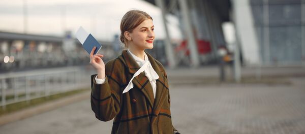 Una joven con un pasaporte en la mano - Sputnik Mundo