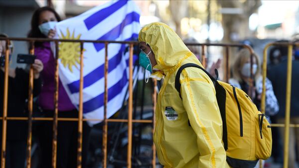 Un hombre con un traje de protección en Montevideo, Uruguay - Sputnik Mundo