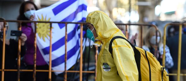 Un hombre con un traje de protección en Montevideo, Uruguay - Sputnik Mundo