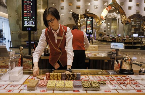 A croupier works at a gaming table at MGM Cotai Resort in Macau A croupier works at a gaming table at MGM Cotai Resort in Macau - Sputnik Mundo