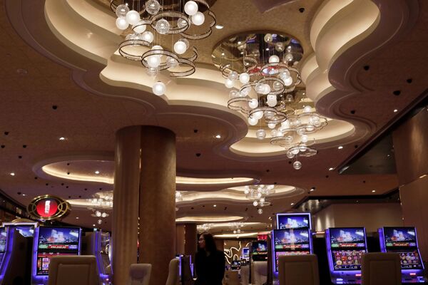 A woman walks past some slot machines at MGM Cotai Resort in Macau A woman walks past some slot machines at MGM Cotai Resort in Macau - Sputnik Mundo