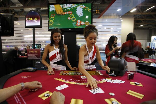 Attendants conduct play with the visitors over a Black Jack gaming table during the Global Gaming Expo Asia in Macau Attendants conduct play with the visitors over a Black Jack gaming table during the Global Gaming Expo Asia in Macau - Sputnik Mundo