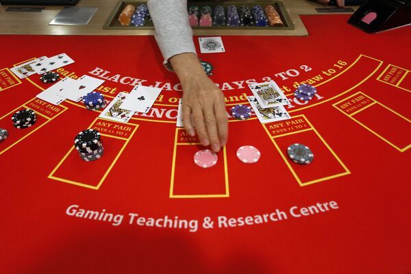 A gambling school student practices on a table in Macau, China A gambling school student practices on a table in Macau, China - Sputnik Mundo