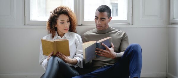 Una pareja leyendo, imagen referencial - Sputnik Mundo