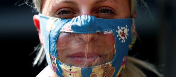 Una mujer con mascarilla transparente Una mujer con mascarilla transparente - Sputnik Mundo