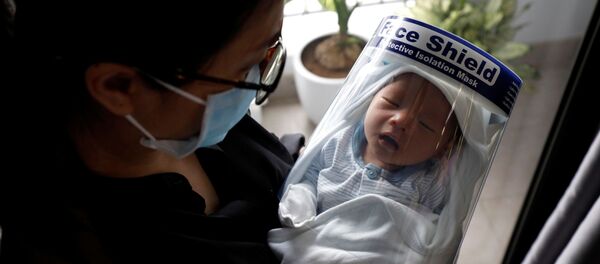 Un recién nacido protegido por una máscara protectora contra el coronavirus - Sputnik Mundo