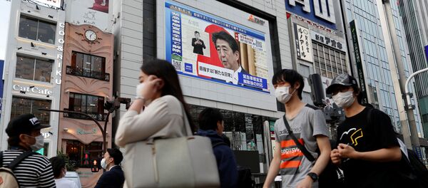 La imagen del primer ministro japonés Shinzo Abe en una pantalla en Tokio La imagen del primer ministro japonés Shinzo Abe en una pantalla en Tokio - Sputnik Mundo