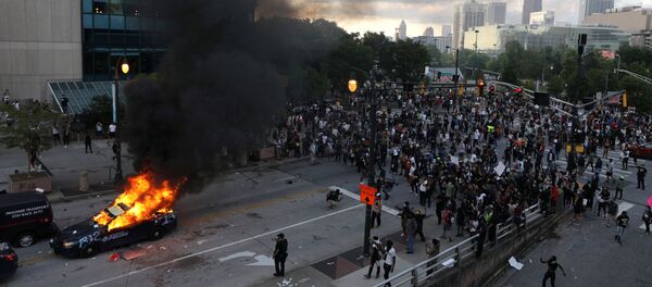 Un vehículo en llamas durante las protestas en Atlanta, Georgia, por la muerte de George Floyd Un vehículo en llamas durante las protestas en Atlanta, Georgia, por la muerte de George Floyd - Sputnik Mundo