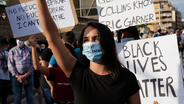 Una manifestante protesta contra la muerte de George Floyd en Barcelona - Sputnik Mundo