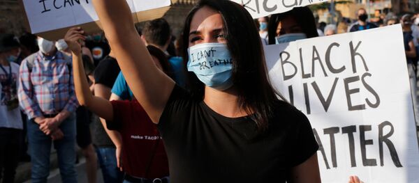 Una manifestante protesta contra la muerte de George Floyd en Barcelona - Sputnik Mundo