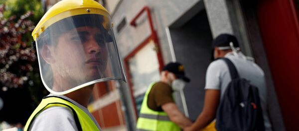 Un voluntario durante el brote de coronavirus en España - Sputnik Mundo