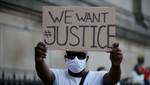 Un protestante durante las manifestaciones por el asesinato de George Floyd - Sputnik Mundo