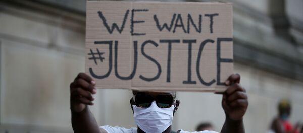 Un protestante durante las manifestaciones por el asesinato de George Floyd - Sputnik Mundo