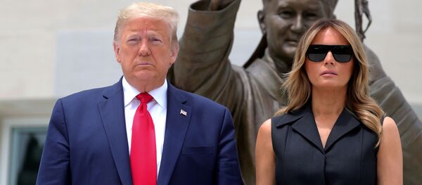 El presidente de Estados Unidos, Donald Trump, y la primera dama, Melania Trump, están frente a una estatua del papa Juan Pablo II - Sputnik Mundo