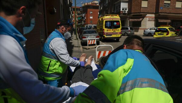Médicos transportan a un paciente con coronavirus en España - Sputnik Mundo