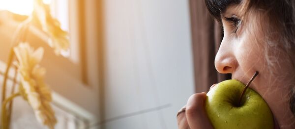 Niña mordiendo una manzana Niña mordiendo una manzana - Sputnik Mundo