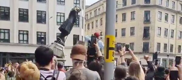 Manifestantes derriban la estatua de Edward Colston durante las protestas en Bristol, el Reino Unido - Sputnik Mundo
