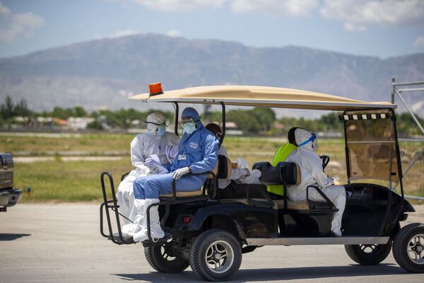 Médicos haitianos en el aeropuerto de Puerto Príncipe se retiran tras realizar controles médicos a haitianos deportados desde EEUU, en mayo de 2020. Desde el comienzo de la pandemia en marzo de 2020, Haití registra más de 19.170 casos positivos y 467 muertes confirmadas causadas por el SARS-CoV-2. - Sputnik Mundo