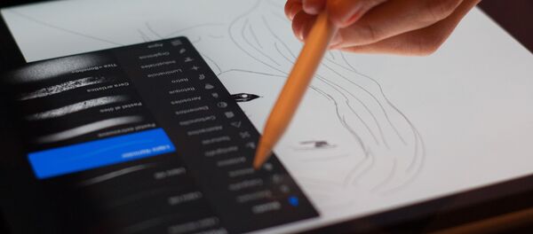 Una persona dibuja en una tableta - Sputnik Mundo