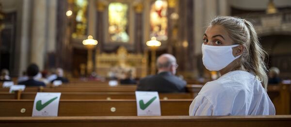 Una mujer acude a misa  - Sputnik Mundo