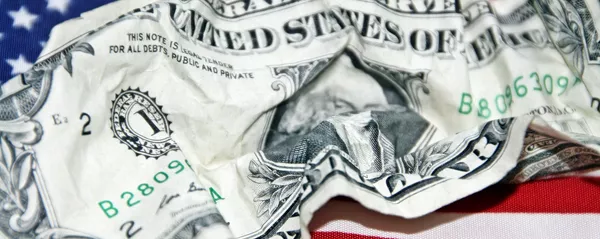 Un dólar arrugado con una bandera estadounidense de fondo Un dólar arrugado con una bandera estadounidense de fondo - Sputnik Mundo