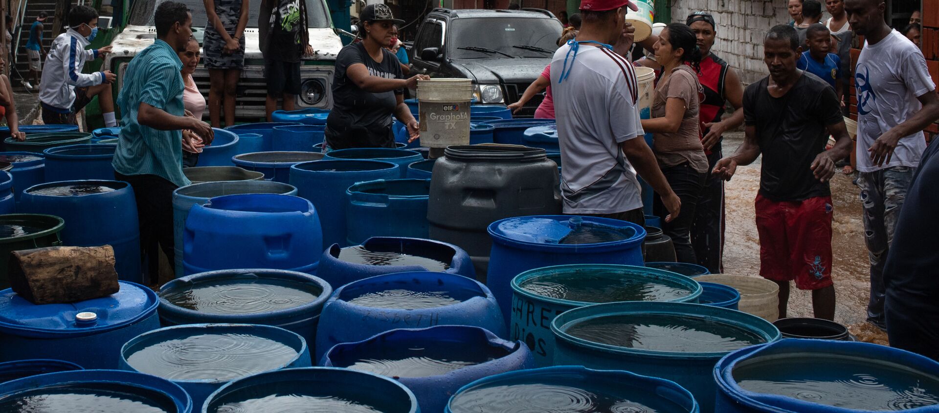 La gente llena los envases plásticos con agua en Petare, Caracas - Sputnik Mundo, 1920, 10.06.2020