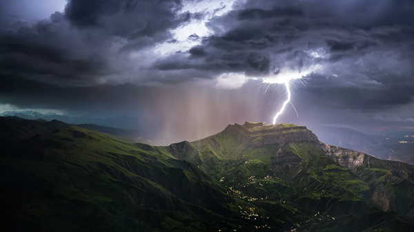 El legendario monte Montura, el más famoso de Daguestán, con un raro fenómeno de la naturaleza: un rayo que cae directamente en la cima.  - Sputnik Mundo