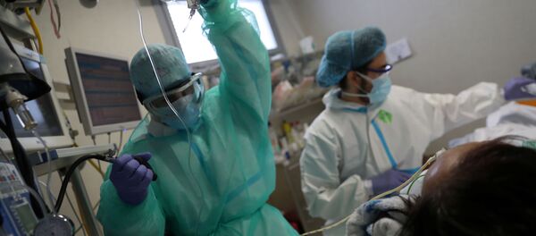Personal médico atiende a un paciente con COVID-19 en España - Sputnik Mundo