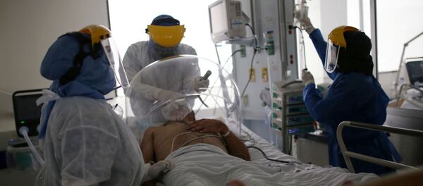 Los médicos atienden a un paciente con coronavirus en Bogotá - Sputnik Mundo