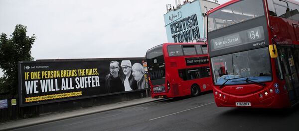 Una pancarta con las imágenes de Michael Gove, Dominic Cummings y Boris Johnson en Londres - Sputnik Mundo