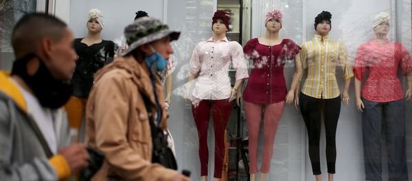 Colombianos caminan frente a tienda de ropa en Bogotá Colombianos caminan frente a tienda de ropa en Bogotá - Sputnik Mundo