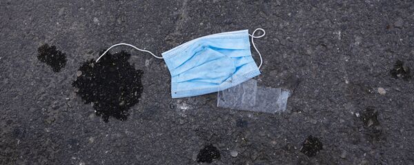 Una mascarilla tirada en el suelo - Sputnik Mundo