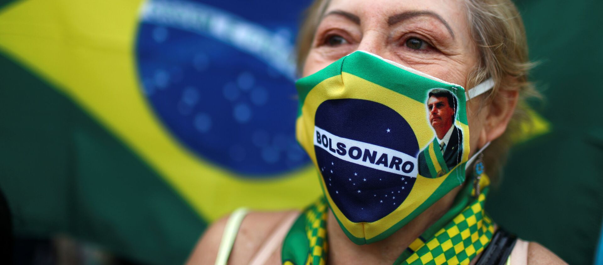 Una mujer brasileña con una mascarilla con la imagen de Bolsonaro Una mujer brasileña con una mascarilla con la imagen de Bolsonaro - Sputnik Mundo, 1920, 25.06.2020