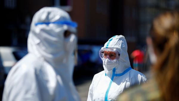 Unos médicos en trajes protectores Unos médicos en trajes protectores - Sputnik Mundo