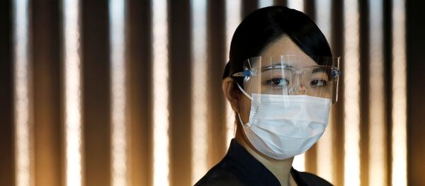 Una mujer con mascarilla y gafas - Sputnik Mundo