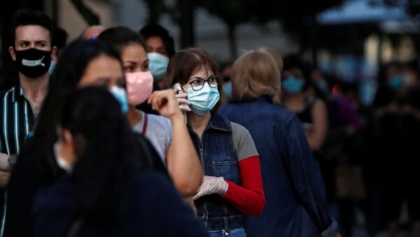 Personas con mascarillas faciales hacen cola para ingresar en una tienda de Madrid - Sputnik Mundo