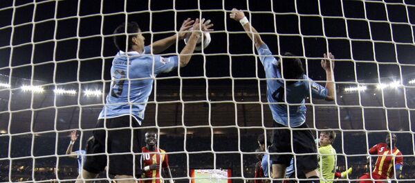 El futbolista uruguayo Luis Suárez detiene la pelota con la mano en el partido frente a Ghana en el Mundial de Sudáfrica de 2010 - Sputnik Mundo