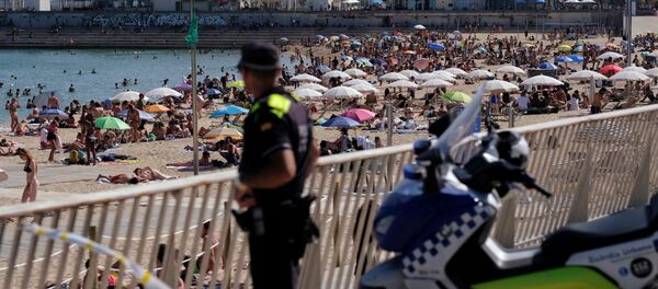 Un oficial de policía observa cómo la gente disfruta en la playa - Sputnik Mundo