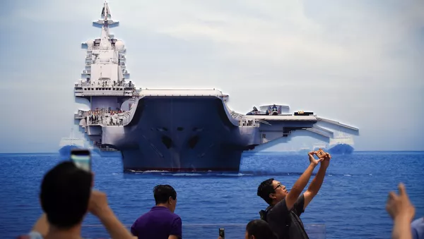 Personas toman fotos de un modelo del portaviones chino Liaoning