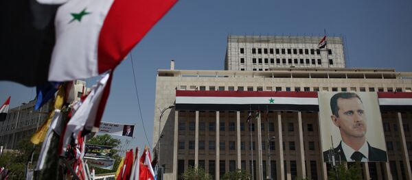 Los retratos del presidente sirio, Bashar Asad, y las banderas en Damasco - Sputnik Mundo