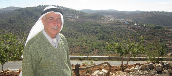 Abás Yusef, un campesino palestino. Detrás, al fondo, se ve uno de los asentamientos de la zona donde están sus olivares - Sputnik Mundo