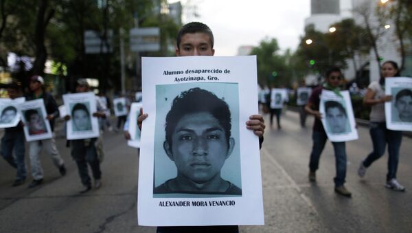 Manifestante con una foto de Alexander Mora Venancio - Sputnik Mundo