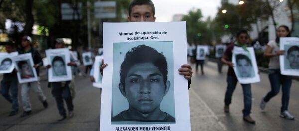 Manifestante con una foto de Alexander Mora Venancio - Sputnik Mundo